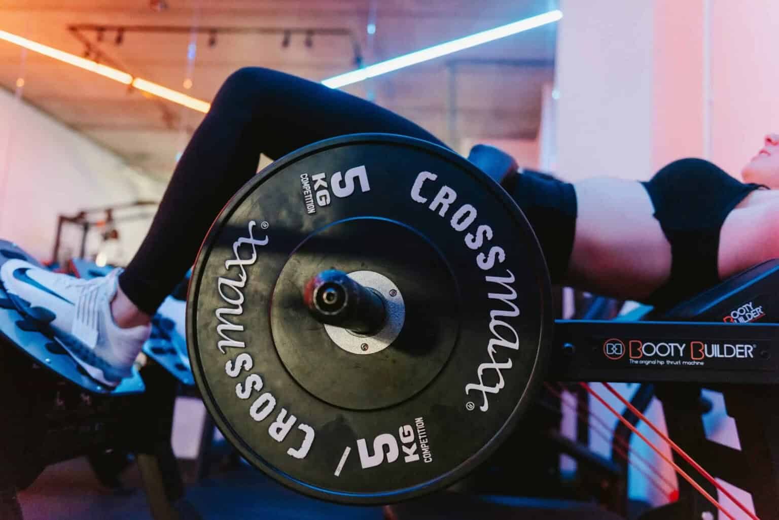 Een vrouw traint haar bilspieren met de hip thrust in de Booty Builder-machine