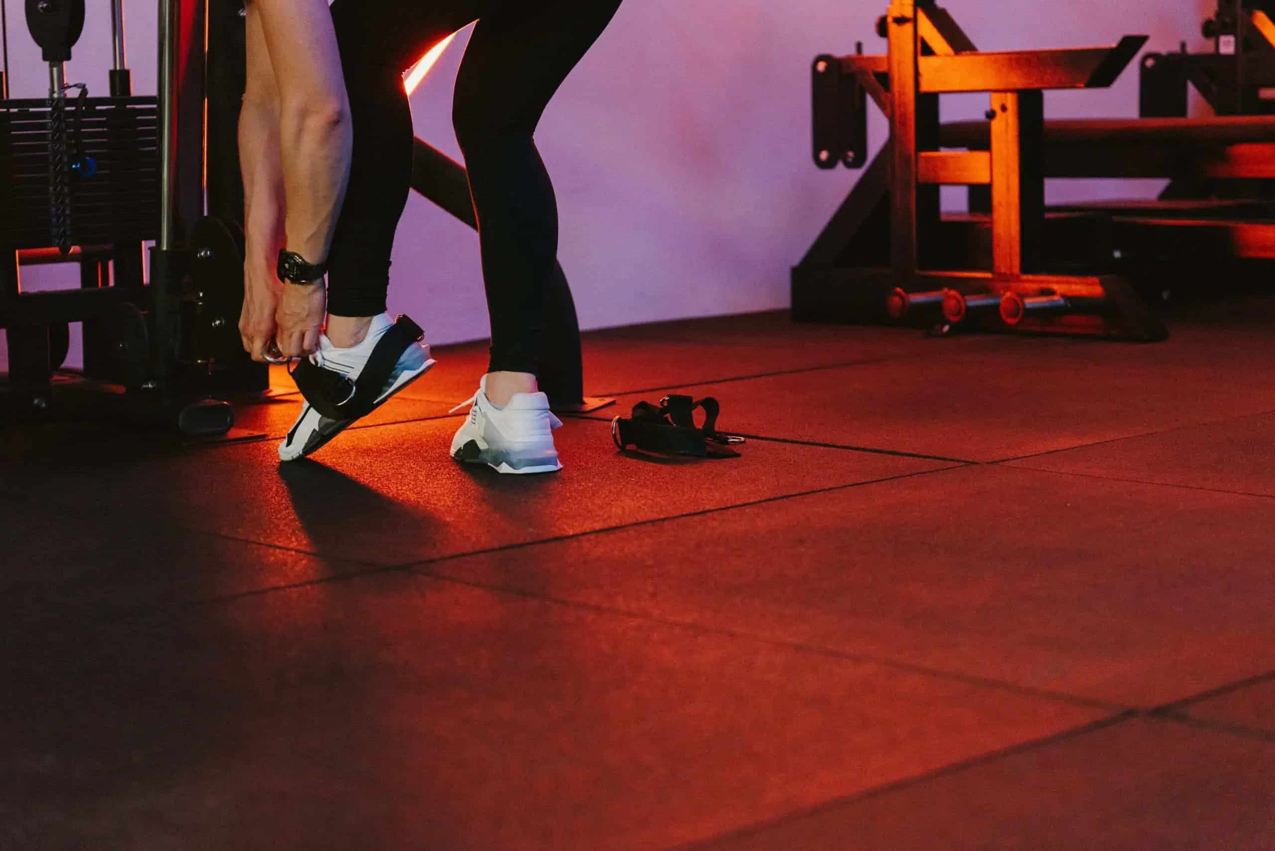 Een sporter maakt zich klaar voor een beentraining in de gym