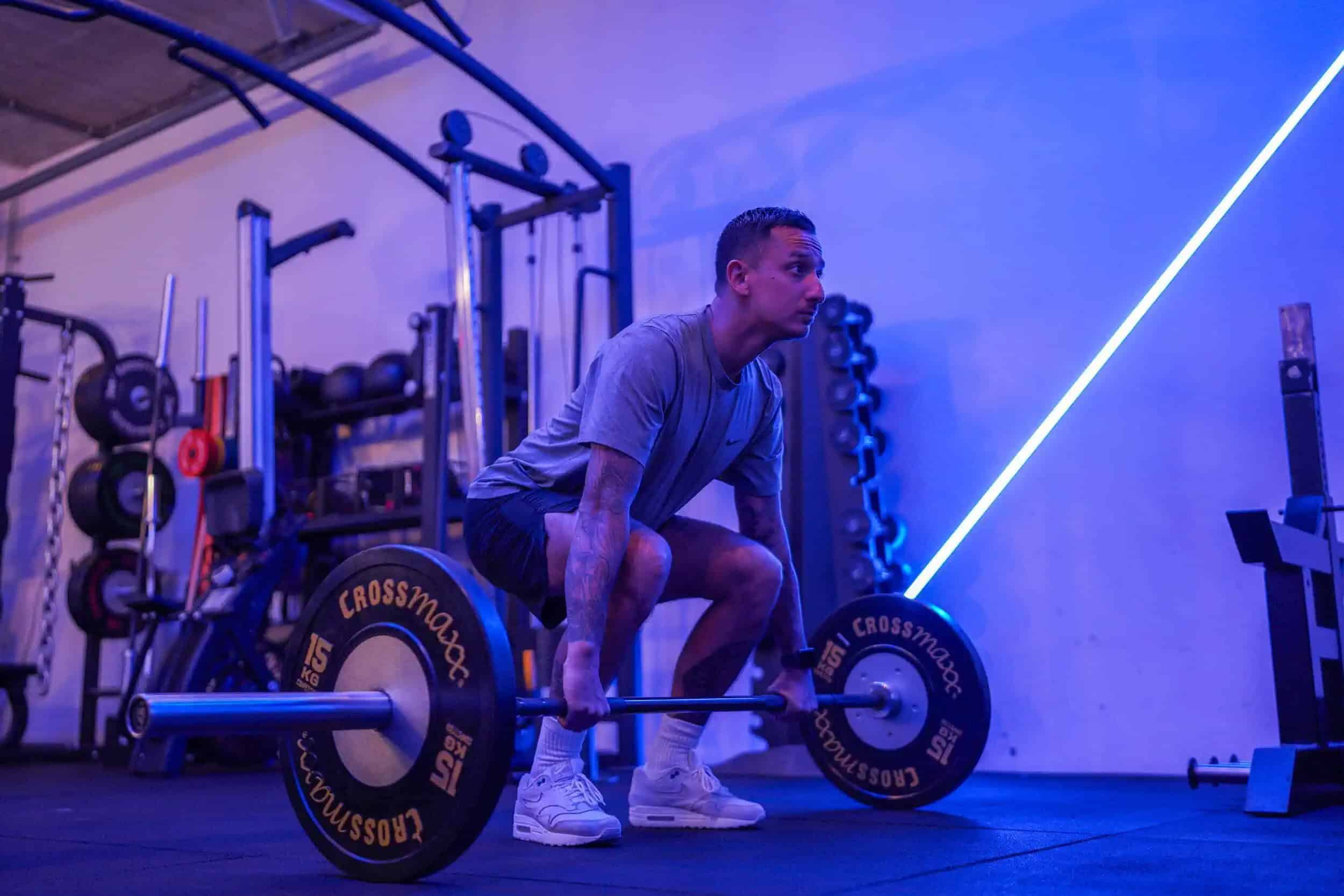 Man in de startpositie van een conventional deadlift met een barbell