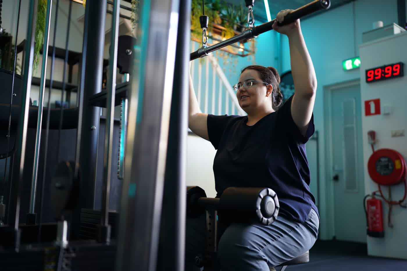 Vrouw in de beginpositie van een lat pulldown