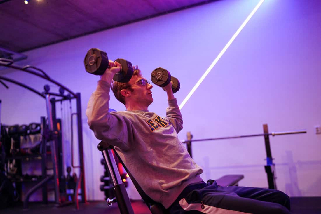 Zittende dumbbell shoulder press met de gewichten op schouderhoogte