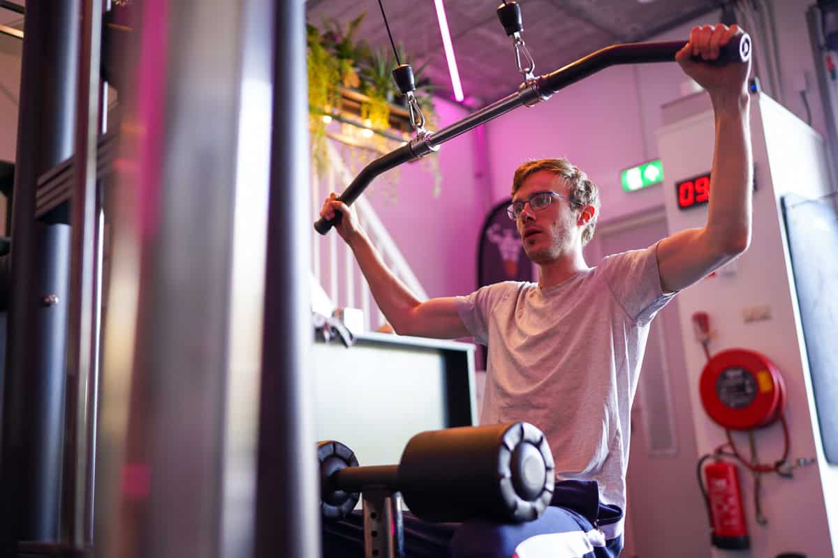 Man doet een lat pulldown met een brede stang