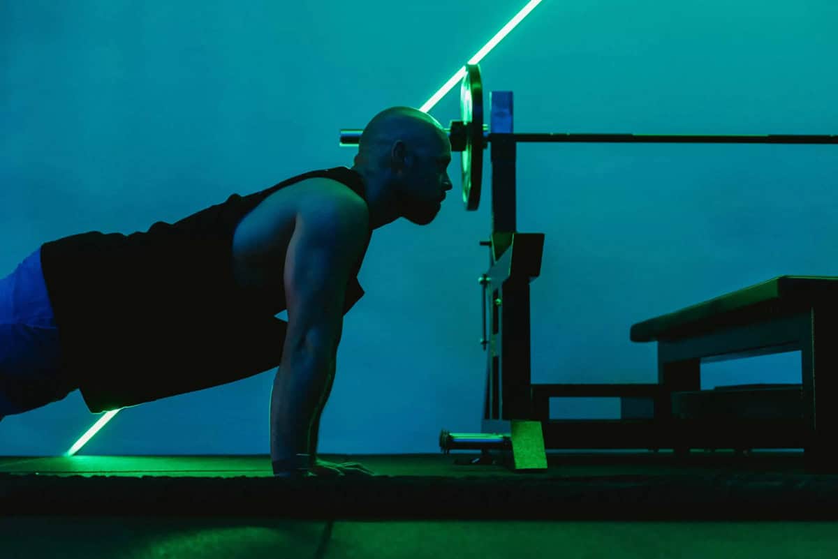 Man in de bovenste positie van een push-up met gestrekte armen