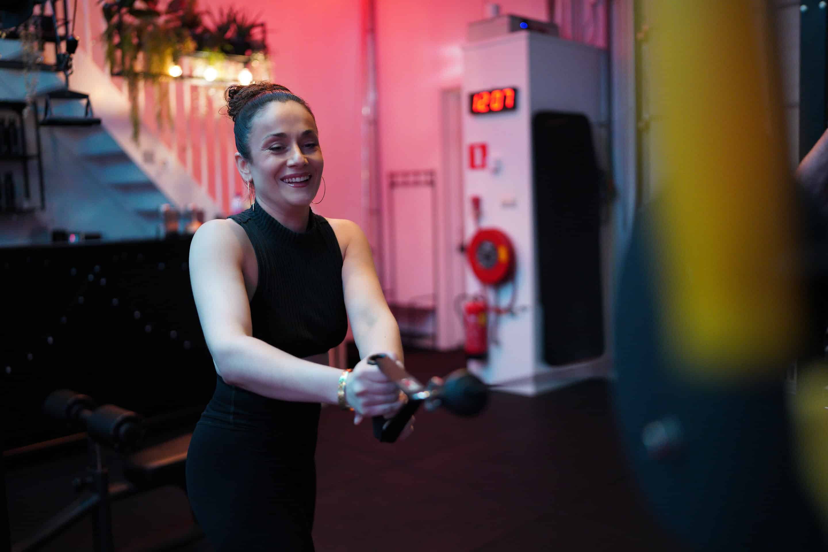 Vrouw traint met een cable machine tijdens een rustige krachttraining