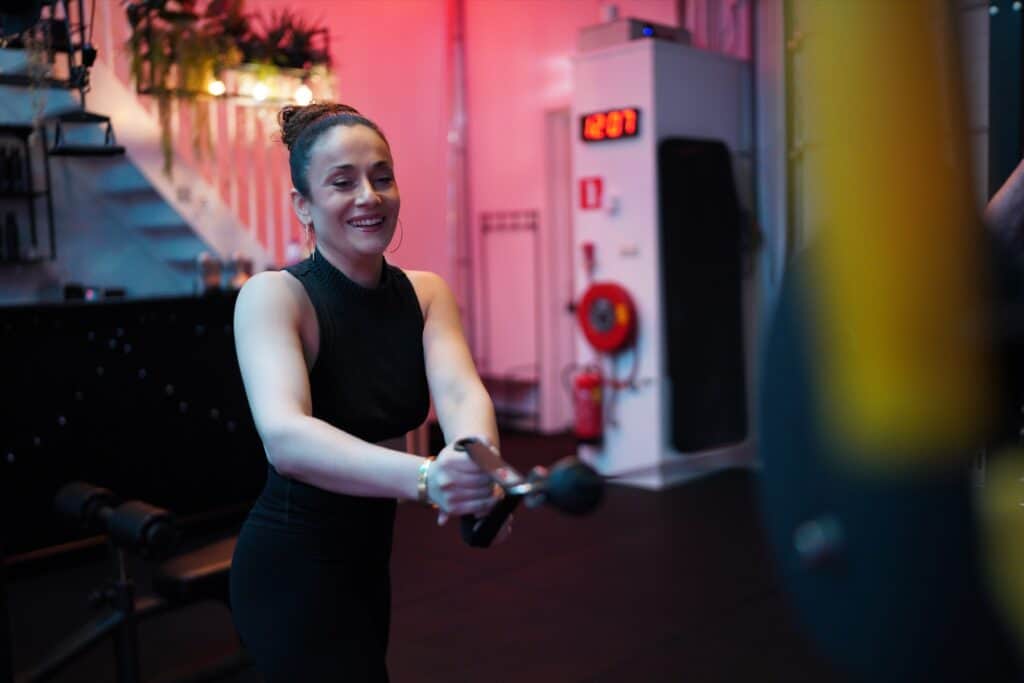 Een vrouw traint met plezier in de privé gym van Jouw Krachtstation in Bodegraven.