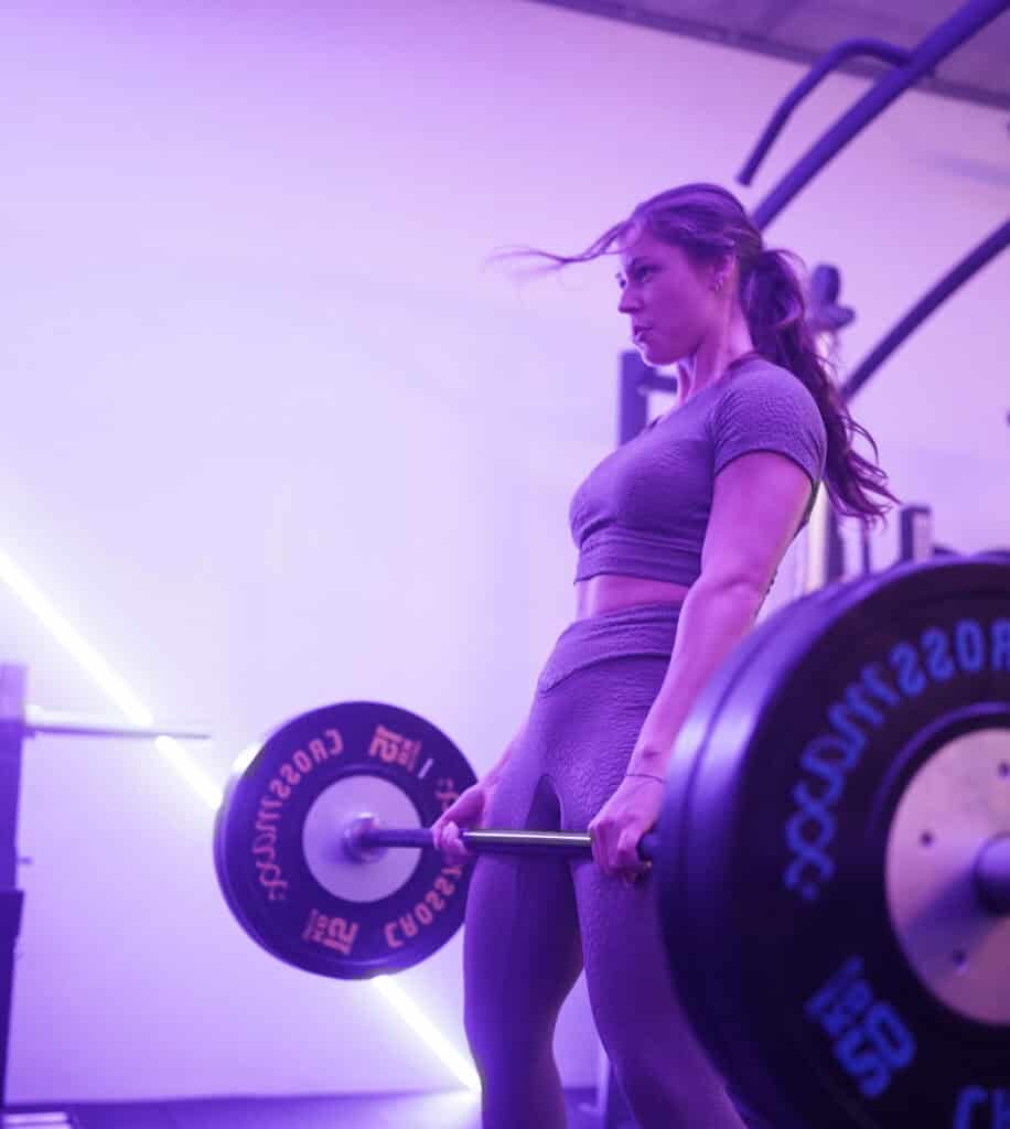 Een vrouw traint met een halter in de privé gym van Jouw Krachtstation.