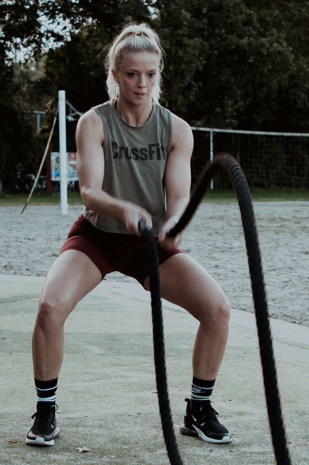 Anja traint buiten met battle ropes.